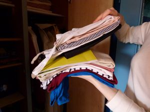 Foto von einem Kleiderstapel, der hochgehoben wird.