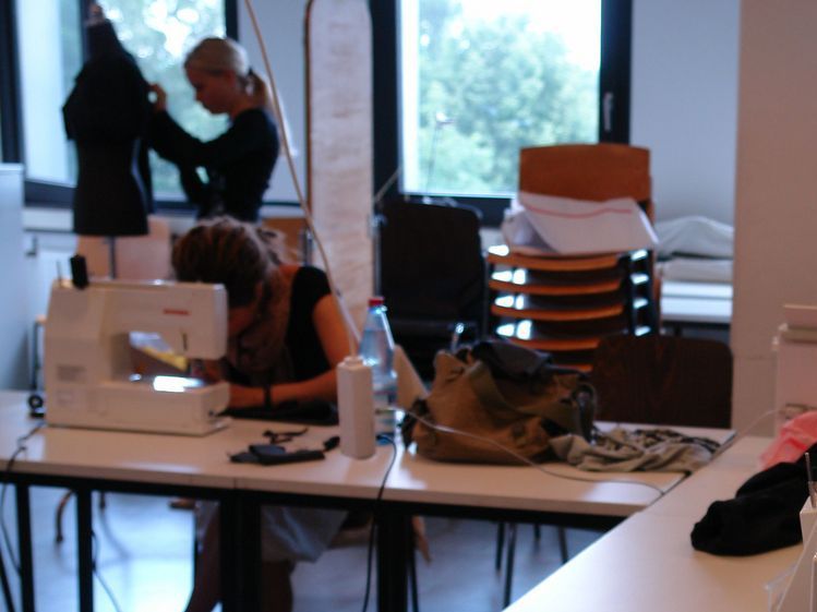 Das Foto zeigt einen Einblick in den Nähraum des Instituts. Dort stehen große Arbeitstische, Nähmaschinen, Schneiderpuppen und alle möglichen Materialien zur Verfügung.