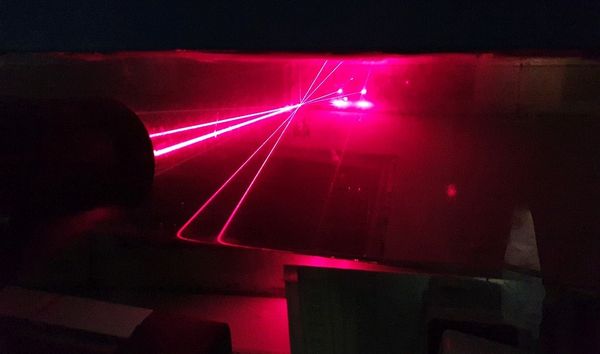 Wind-wave tank experiment with the LDV (left) located beside the wind-wave tank, looking into the air side in the tank and measuring velocities in the (xz) plane.