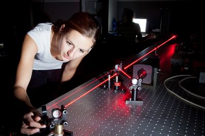 female scientist doing research in a quantum optics lab  IQ, applied, beam, center, college, cord, danger, energy, experiment, female, field, glasses, goggles, green, intelligence, lab, laboratory, laser, light, optics, photon, physics, power, protective, quantum, research, result, school, science, scientist, selective, source, spark, student, study, test, university, young