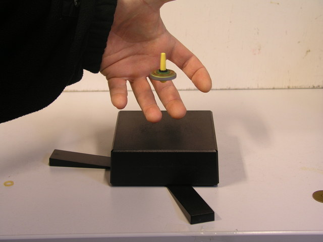 Levitierender Kreisel. Foto einer Hand und eines levitierenden Kreisels.