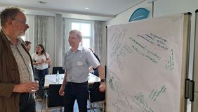 2 participants in front of paper tablecloth