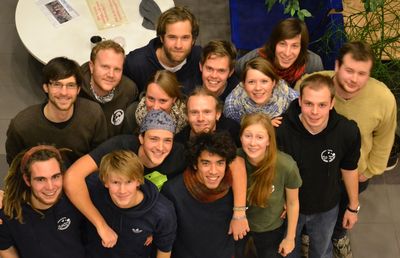 Das Foto zeigt den Fachschaftsrat Umweltwissenschaften für Winter- & Sommersemester 2012/13. Zu sehen sind 15 Studierende, alle im Alter von Anfang bis Ende 20. Sie tragen alle bunte Pullover , Jacken oder T-Shirts mit dem Logo der Fachschaft.  Sie stehen in mehreren Reihen. Das Foto wurde im ICBM und von weit über den Köpfen der Personen aufgenommen. Im Hintergrund ist ein grauer Fließenboden zu sehen und zwei Tische.
