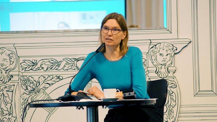 Bild von Frau Pasewalck, während sie auf einer Veranstaltung an einer Podiumsdiskussion teilnimmt. 