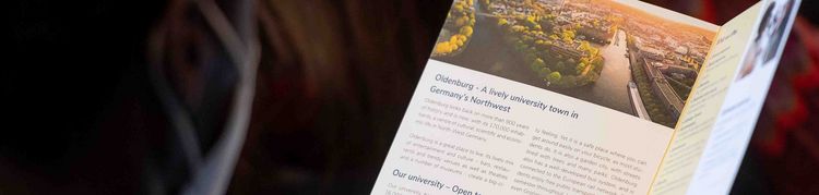 Orientierung fürs Studium Person sieht sich eine Informationsbroschüre an