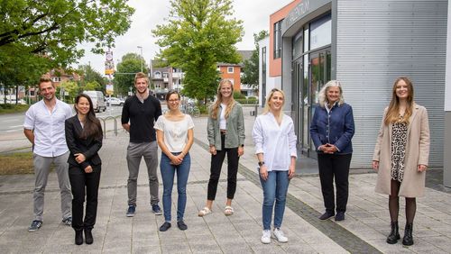 Die acht Personen stehen vor dem Hörsaalzentrum.