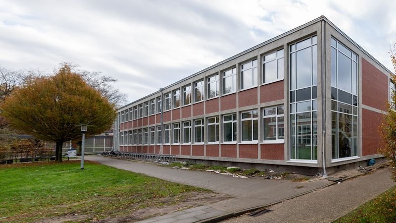 Ein zweigeschossiges Backsteingebäude, dessen vordere Ecke nahezu voll verglast ist.