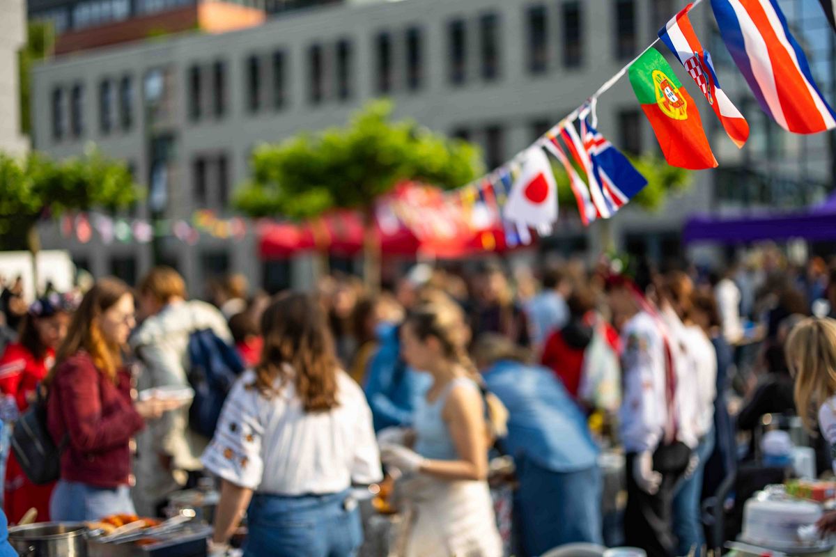 Atmosphäre auf dem Sommerfest: im Vordergrund sind Flaggen-Girlanden, der Rest ist verschwommen 