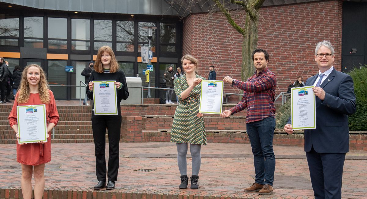 Halten Auszeichnung hoch von links nach rechts: Johanna Zier, Helena Post und Johanna Belz vom AStA, Christian Jorge Vinz vom Studentenwerk Oldenburg und Vizepräsident Jörg Stahlmann.