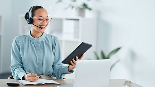 Callcenter-Agent, der anruft, spricht und auf Laptop und Tablet ein Geschäft oder einen Verkauf vermarktet. Lächelnde, erfolgreiche und freundliche freiberufliche Support-Mitarbeiter,