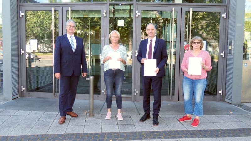 Vier Personen stehen vor dem Eingang des Hörsaalzentrums