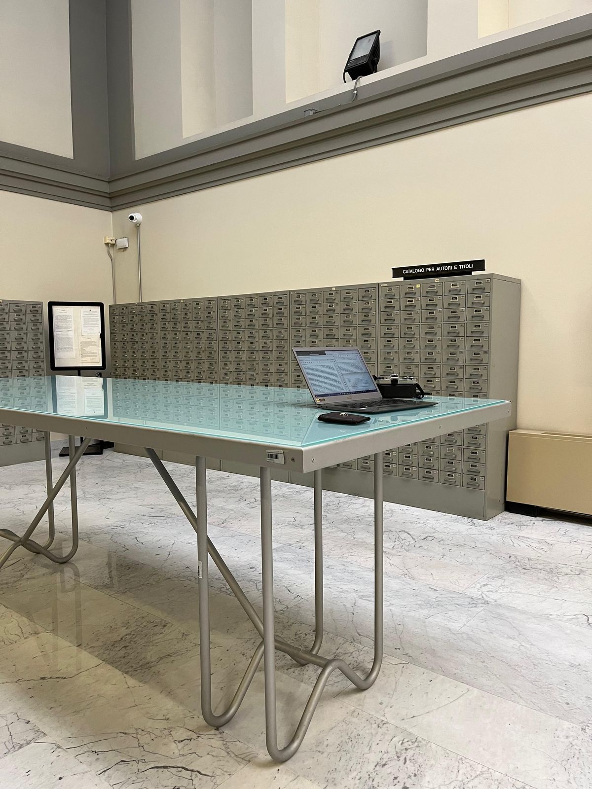 Arbeiten in der Bibliothek in der Ferne. Alleine forschen weit weg von allen(m) — Carla Kleinschmidt — Alleine im Kühlen - Teil von Forschung sind diese ruhigen, einsamen Momente in Bibliotheken. Die Aufnahme ist in Florenz im Auslandssemester entstanden. Sie zeigt meinen Arbeitsplatz in der Fremde, die mich mit so viel Wärme und Herzlichkeit empfangen hat, dass ich in die kühle Bib gewandert bin. Florenz bietet auch die gegenteilige Bibliothek: draußen auf dem Balkon in der Sonne mit Gruppenplastiktischen, die wir in der Freundesgruppe viel genutzt haben. Lernen durch Begegnungen und neue Eindrücke. EU danke für Erasmus.