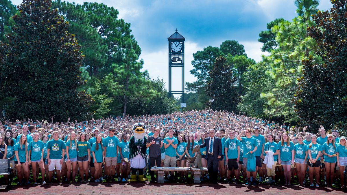 UNCW Studierende stehen vor dem Clock Tower auf dem Campus
