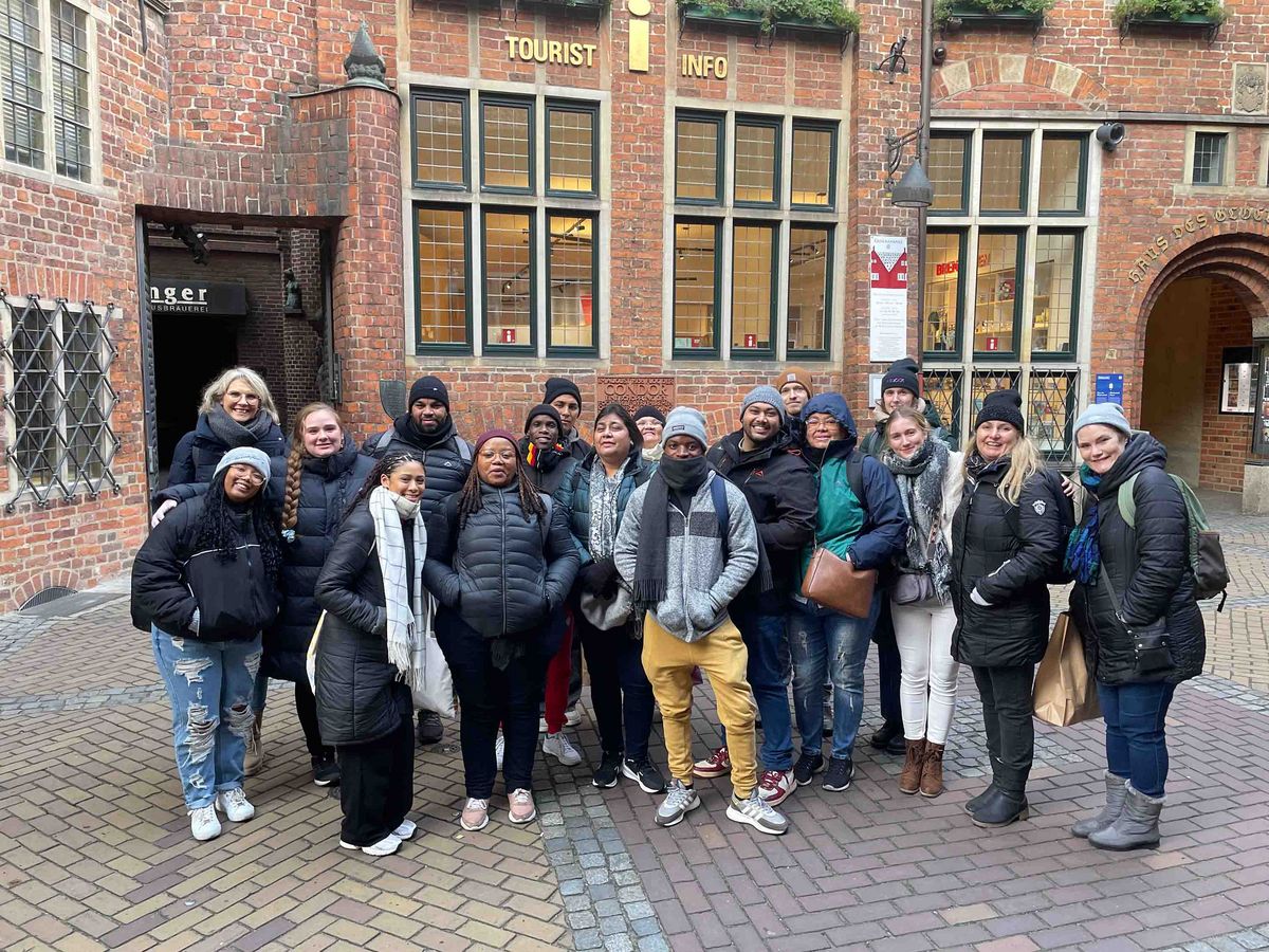 DAAD Winter School 2024 A group of participants at the DAAD Winter School in front of a historic building in Bremen, which houses the Tourist Info.