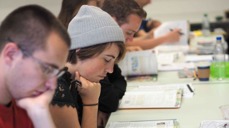 Studierende im Deutschkurs Zwei junge Menschen arbeiten konzentriert an einem Tisch.