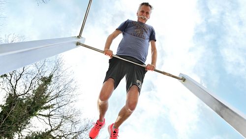 Martin Hillebrecht stützt sich auf ein Reck. Weil das Foto vom Boden aufgenommen ist, sieht man über ihm den Himmel.