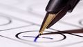 Fountain pen makes a cross on a piece of paper