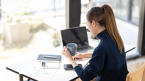 Auf dem Bild ist eine junge Frau im Homeoffice zu sehen.
