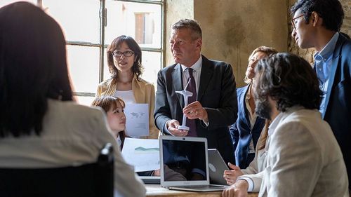 Führungskraft bespricht Windenergie mit diversem Team