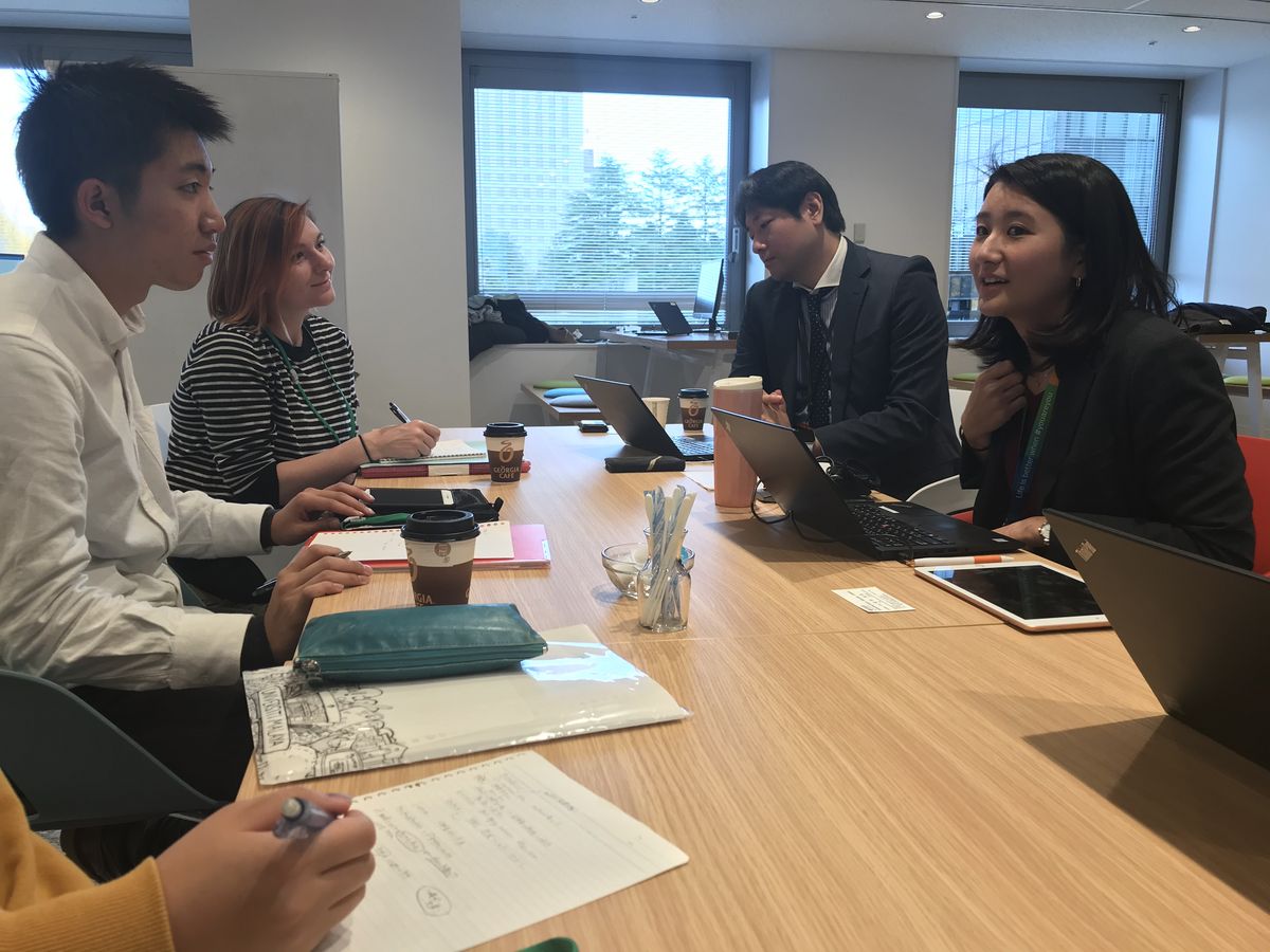 Foto Tohoku 5 Personen die an der Tohoku University an einem Tisch sitzen und sich Unterhalten und Dinge notieren.