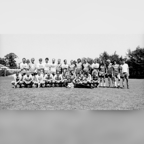 Das Bild zeigt die beiden Fußballmannschaften. Sie stehen auf einem Bolzplatz und schauen in die Kamera.