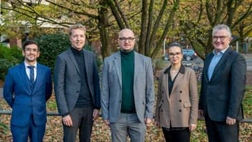 Festlich gekleidete Preisträger in herbstlicher Umgebung.