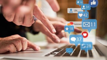 Finger auf einer Tastatur, von der Benachrichtigungssymbole verschiedener Apps aufsteigen.