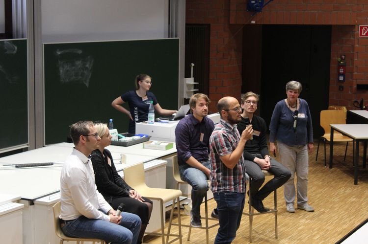 Menschen erzählen etwas dem Publikum im großen Hörsaal
