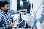 Ein Mann mit Karohemd bedient ein Kernspinresonanz-Spektroskop