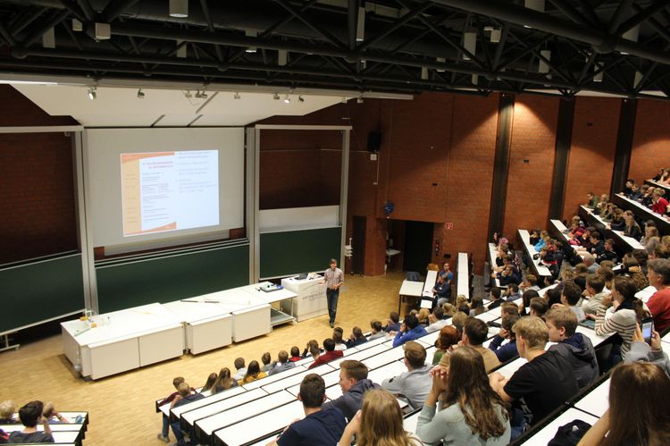 Ein Professor hält einen Vortrag im großen Hörsaal.