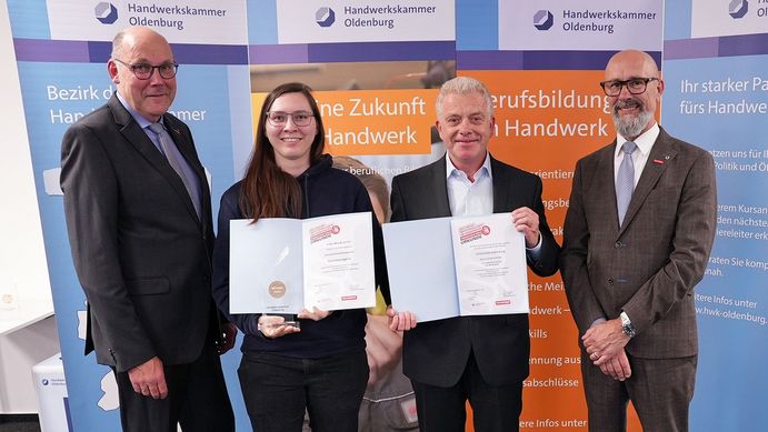 Das Bild zeigt Eske Kranich mit den drei Männern. Sie und Frank Steltenpohl halten je eine Urkunde in die Kamera. Alle lächeln. Im Hintergrund steht ein Aufsteller mit dem Logo der Handwerkskammer Oldenburg.