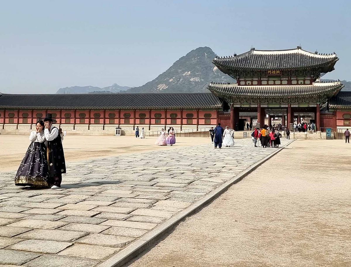 Gyeongbokgung Palast in Seoul  Der Gyeongbokgung Palast in Seoul mit traditionellen Gebäuden und Besucher*innen in Hanboks.