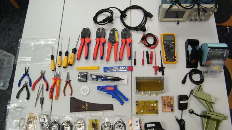 Another wimmelpicture: Pliers, measuring devices, cables and tools lie on a table.