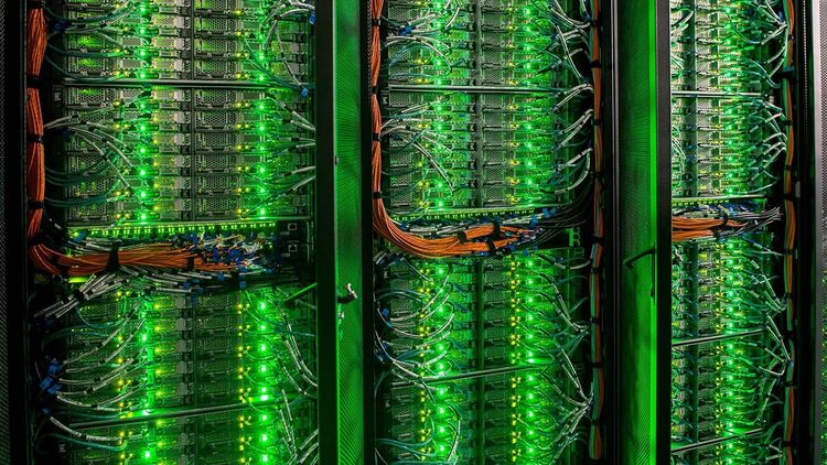 Close-up of a high-performance computer. Rows of green LEDs and numerous cables can be seen.