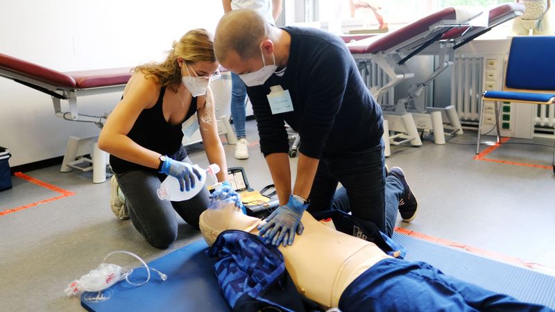 Eine Studentin und ein Student erproben die Reanimation an einer Puppe.