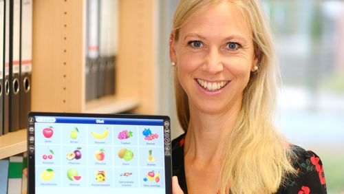 Rebecca Diekmann mit einem Tablet, auf dem die Ernährungs-App zu sehen ist.