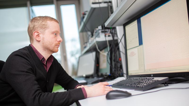 Wissenschaftler sitzt vor Computerbildschirm.