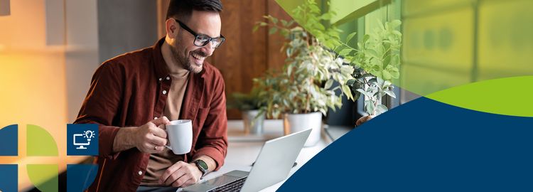 Ein Mann hält eine Kaffeetasse und guckt auf einen Laptop.