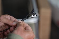 Zwei Hände sind zu sehen, die eine Art Strauß halten: Die Sensoren sind vielleicht so groß wie eine Heftzwecke, daran ist ein etwa zehn Zentimeter langer Draht befestigt. die Antenne