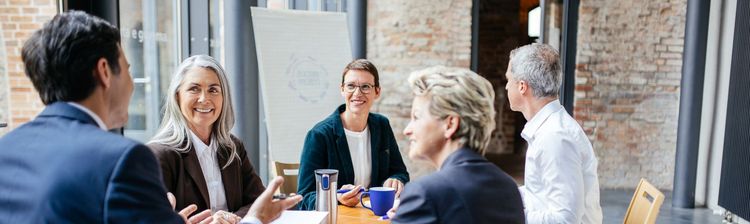 Erasmus+ Personalmobilität Mitarbeiter im Ausland an einem Tisch sitzend