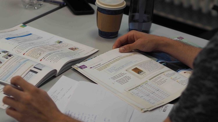 Deutschkurs Eine Draufsicht auf einen Lernplatz mit Lehrbüchern und Arbeitsblättern.