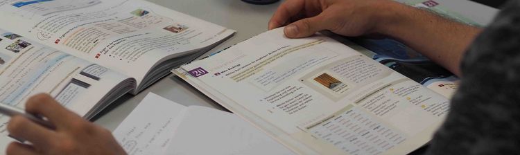 Deutschkurs Eine Draufsicht auf einen Lernplatz mit Lehrbüchern und Arbeitsblättern.