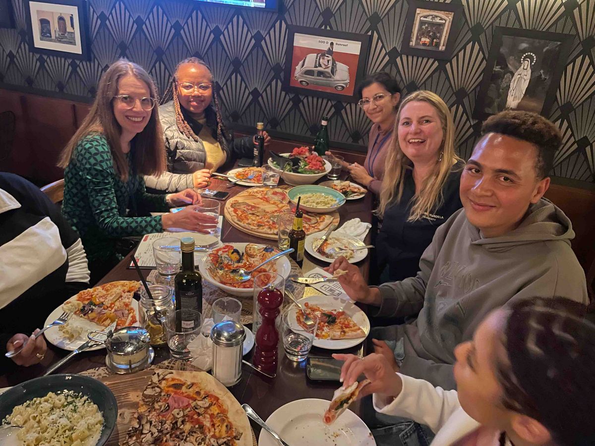 DAAD Winter School 2024  A group of participants at the DAAD Winter School having pizza in a restaurant.