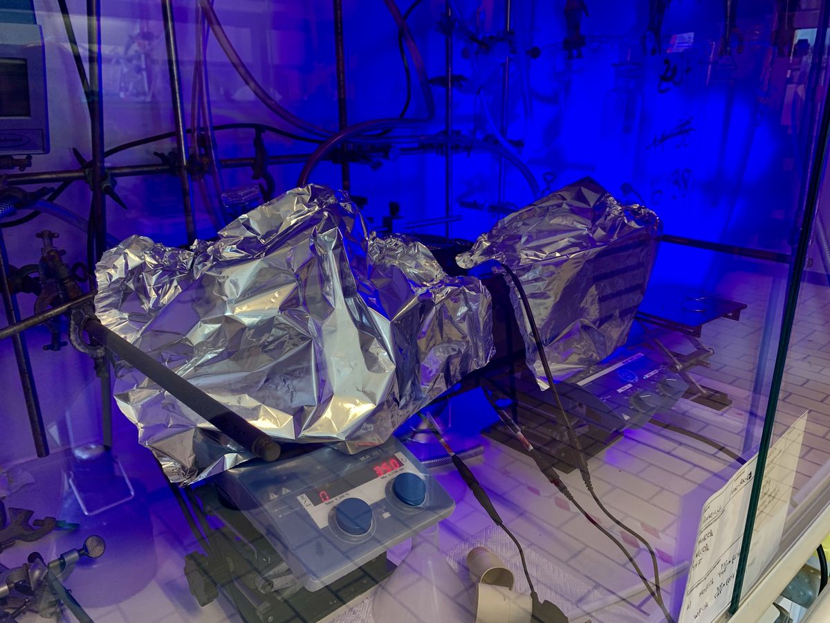 Chemische Reaktion mit UV-Strahlung — Antonia Kallage — Dieses Foto ist im Rahmen des Projekts „Forschendes Lernen - Photochemische Reaktionen in der Anorganischen Chemie“ entstanden und zeigt einen Abzug, in dem eine Reaktionslösung mit UV-Licht bestrahlt wird. Die angebrachte Alufolie dient dem Schutz der Augen vor der schädlichen UV-Strahlung. 