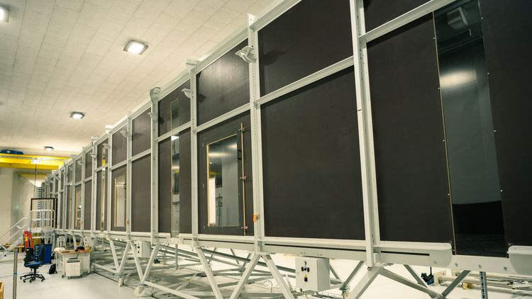 Exterior view of the wind tunnel. The elements are arranged in a row in a large hall.