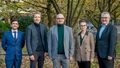 Festively dressed award winners in autumnal surroundings.
