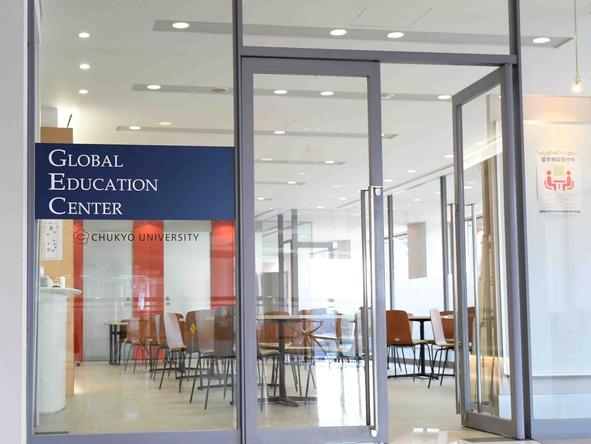 Ein Glasflügel mit dem Schild "Global Education Center" an der Tür. Im Hintergrund ist ein Raum mit Tischen und Stühlen zu sehen. Das Logo der Chukyo Universität ist ebenfalls auf der Tür angebracht.