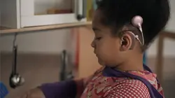 Ein Mädchen mit Cholea-Implantat am Ohr spielt.