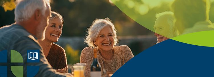 Ältere Menschen sitzen zusammen am Tischen und reden lächelnd miteinander.