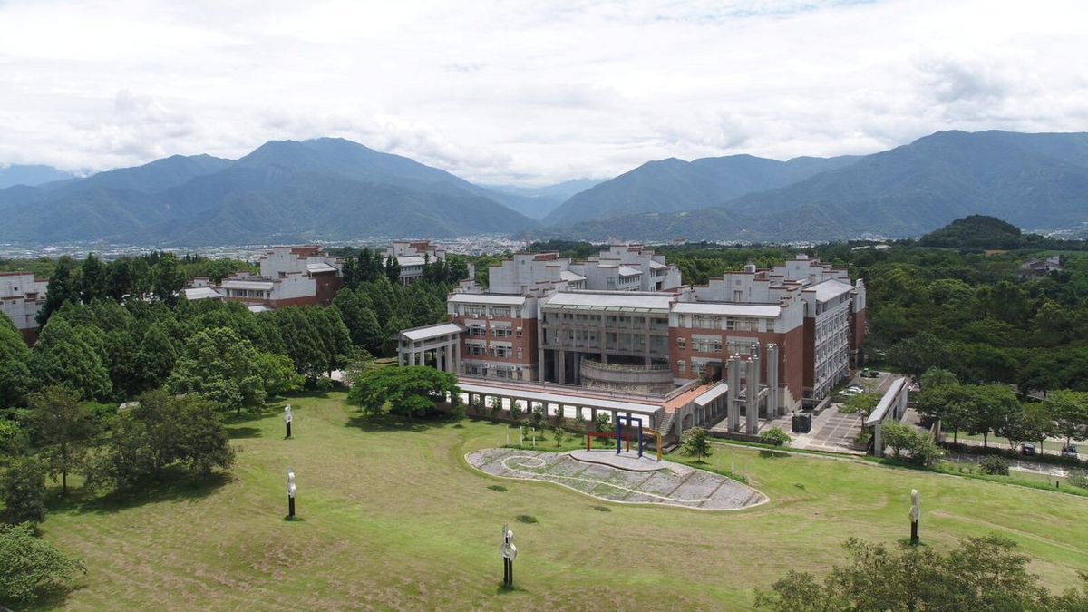 Das Bild zeigt einen Überblick über den weitläufigen Campus der National Chi Nan University mit seinen Gebäuden, Grünflächen und dem beeindruckenden Bergpanorama im Hintergrund.